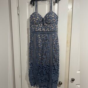 Periwinkle blue crocheted detailing over a nude underlay cocktail dress.